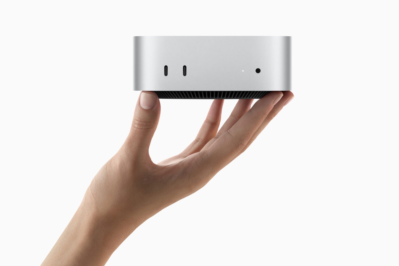 Hand holding the tiny new Mac mini with two ports on the front