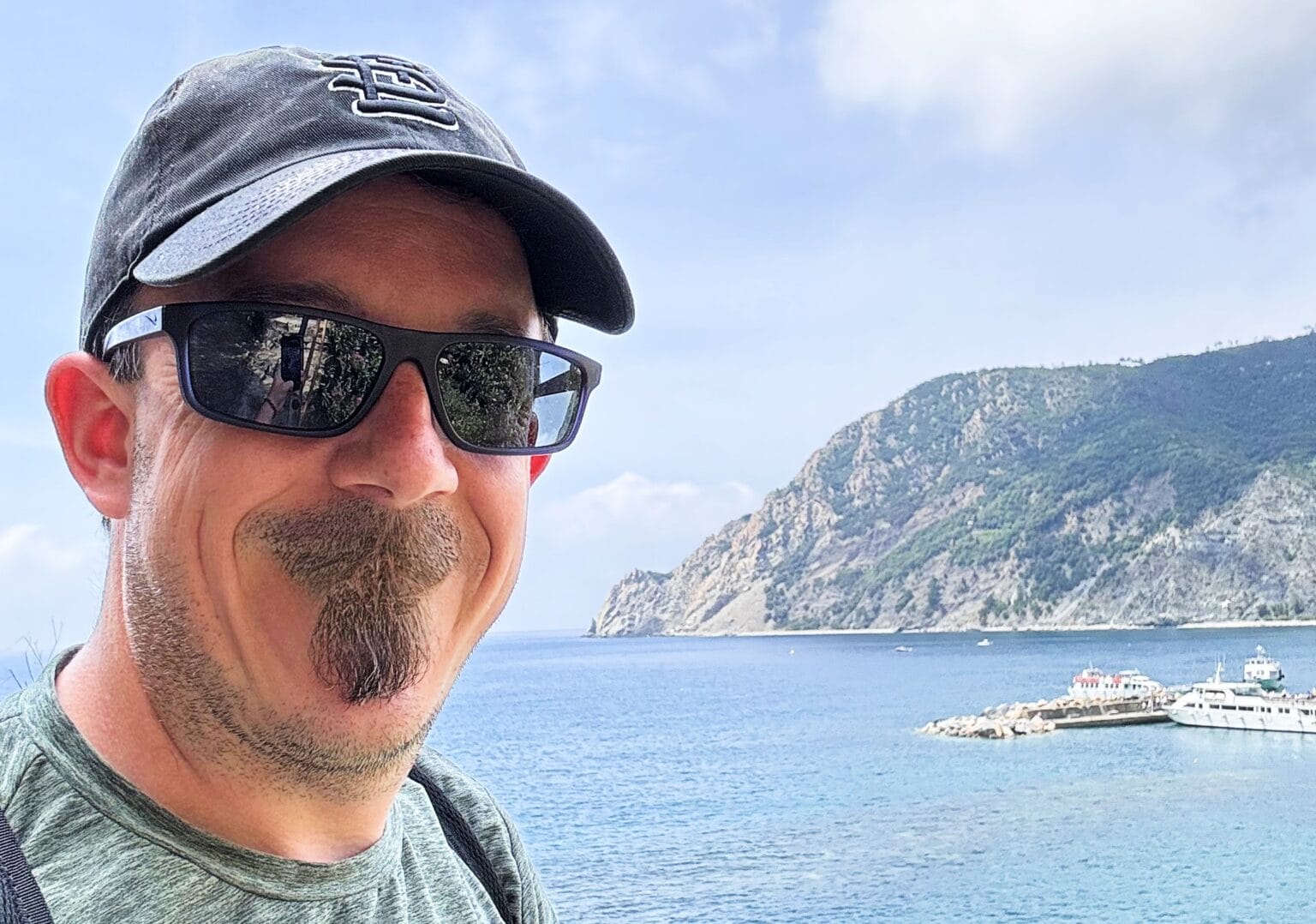 A photo edited with Apple Photos' AI-powered Clean Up feature shows a man with a hideously overgrown soul patch.