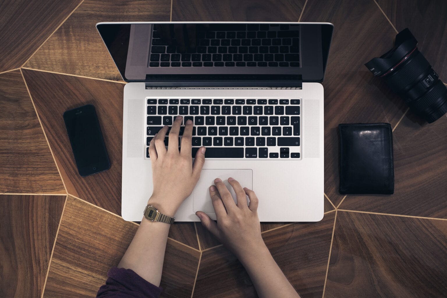 Stock photo of someone with their hands on a MacBook keyboard.