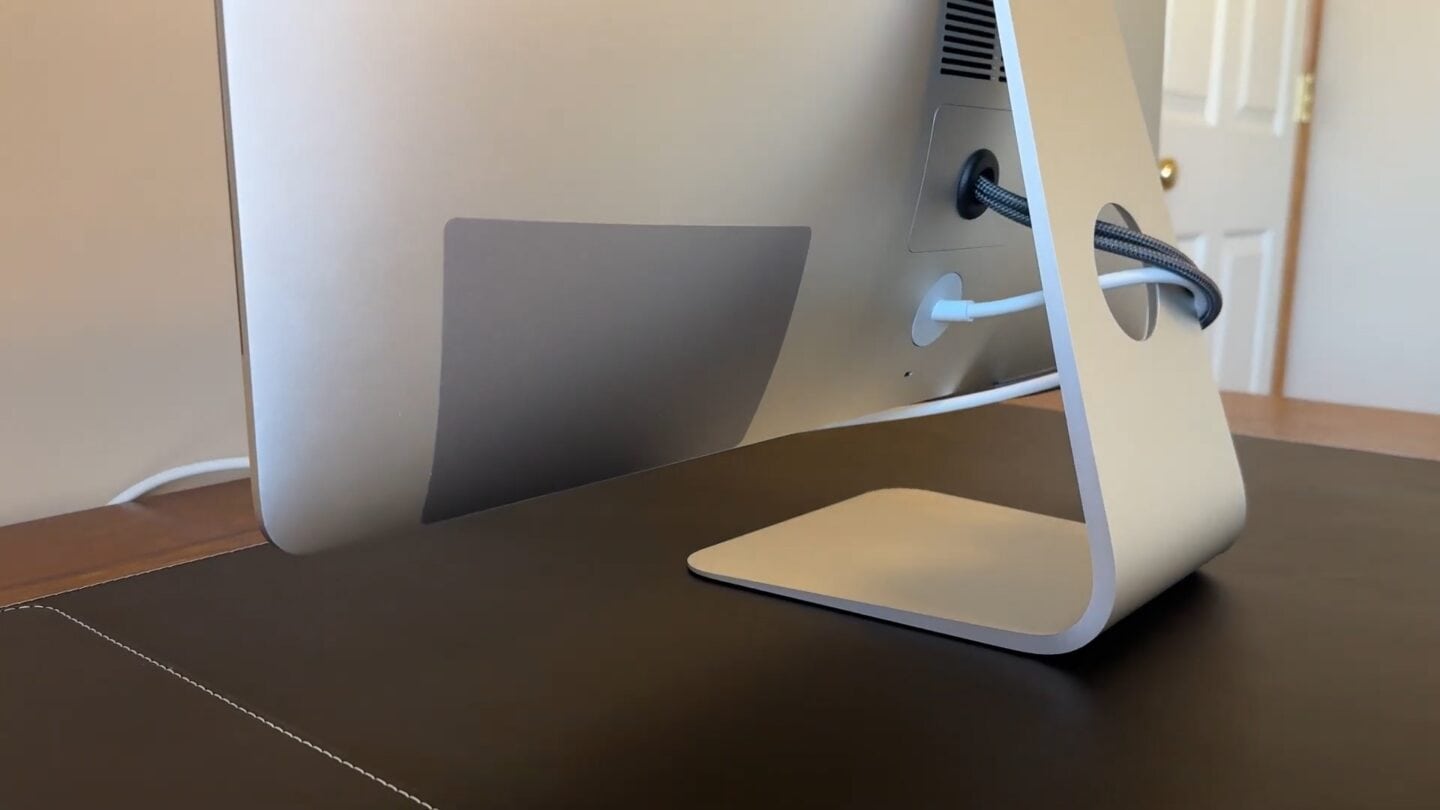 iMac rear, with a cover hiding the ports and a nicely reinstalled RAM door with a rubber grommet protecting the cables coming out.