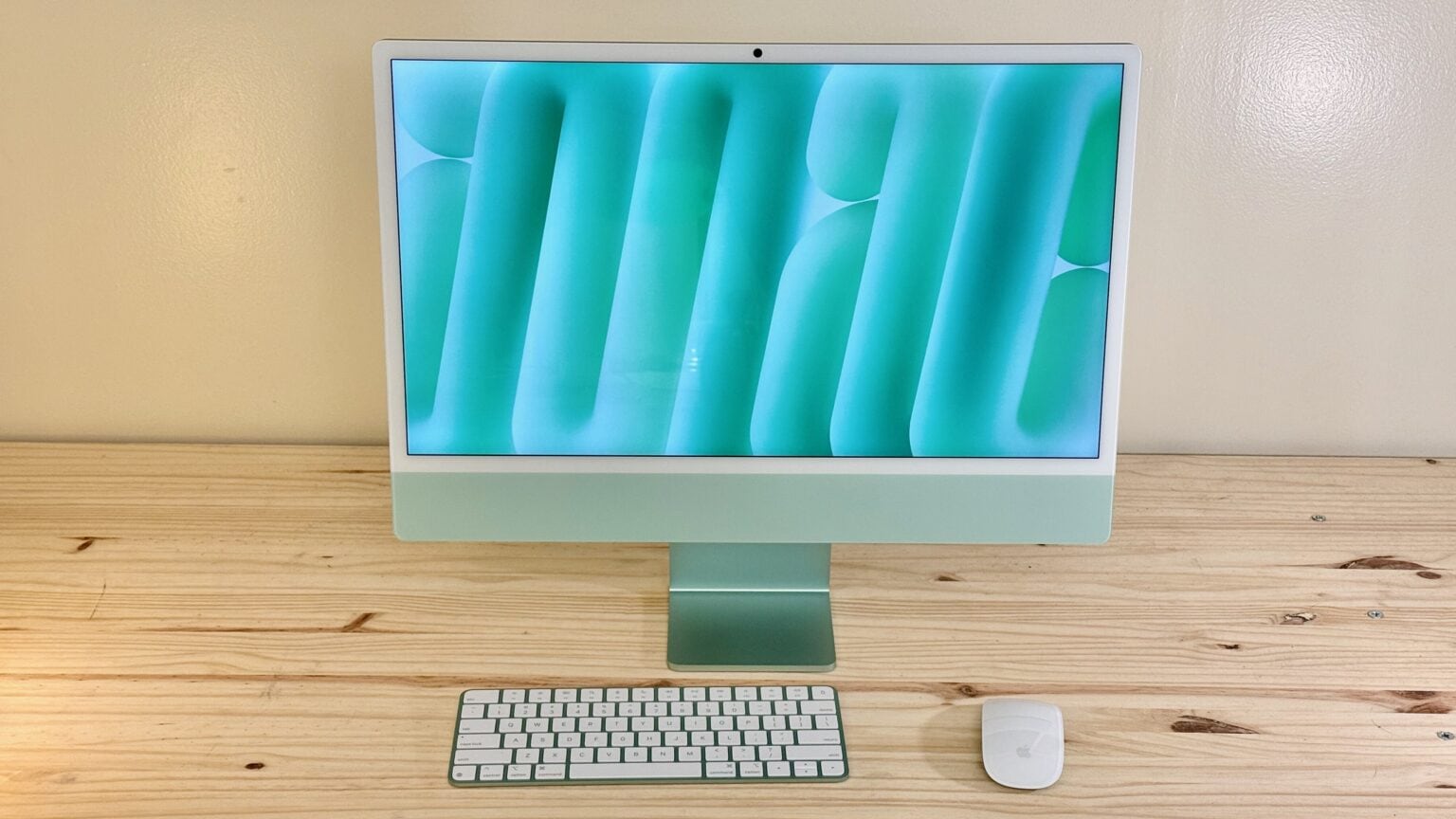 Green iMac sitting on a light wood table