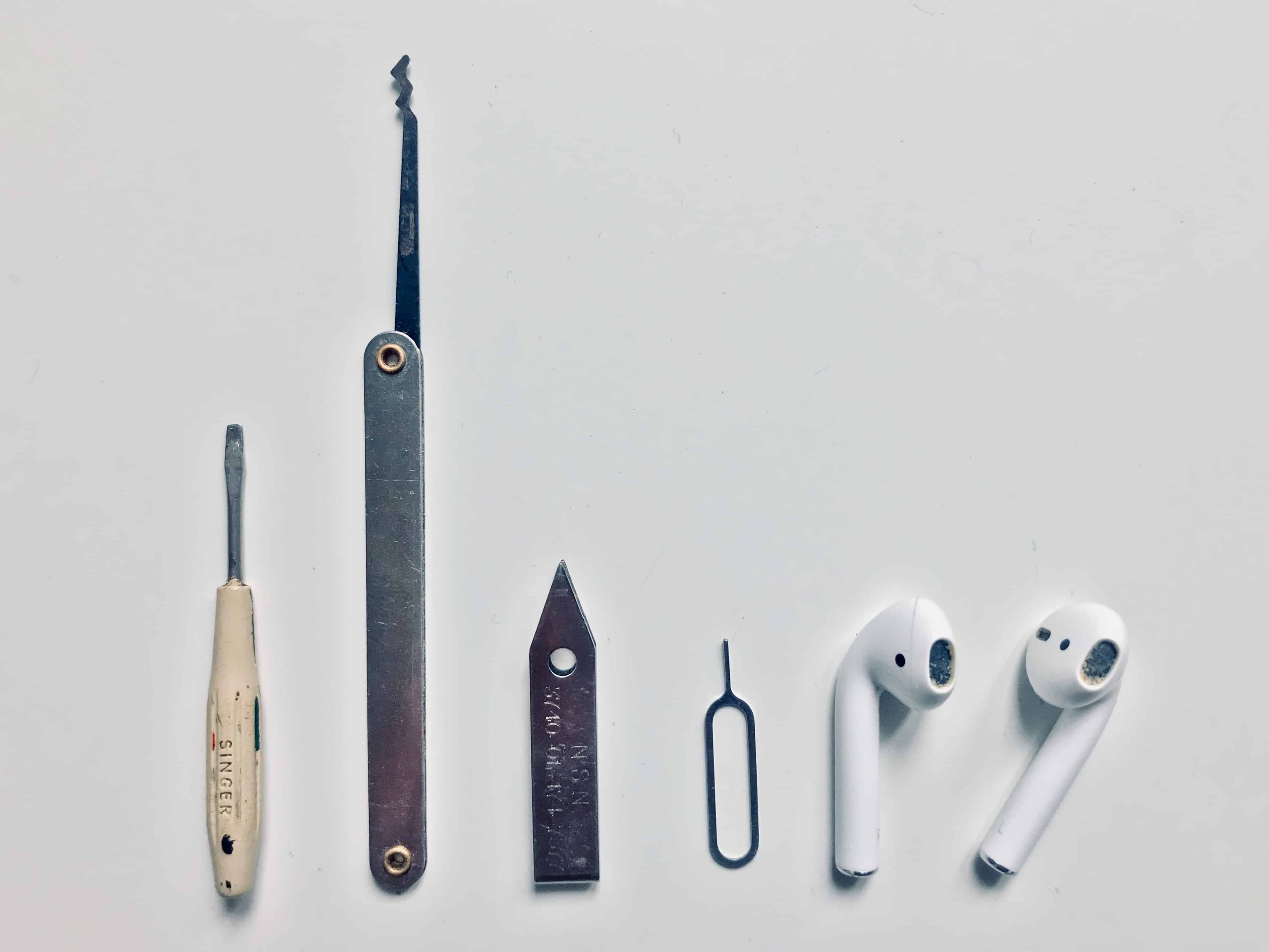 A photo of tools needed to clean earbuds, along with a pair of AirPods.