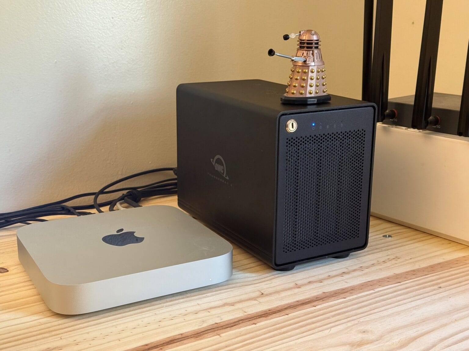 M2 Mac mini next to OWC ThunderBay 4 with a small toy Dalek sitting on top of it