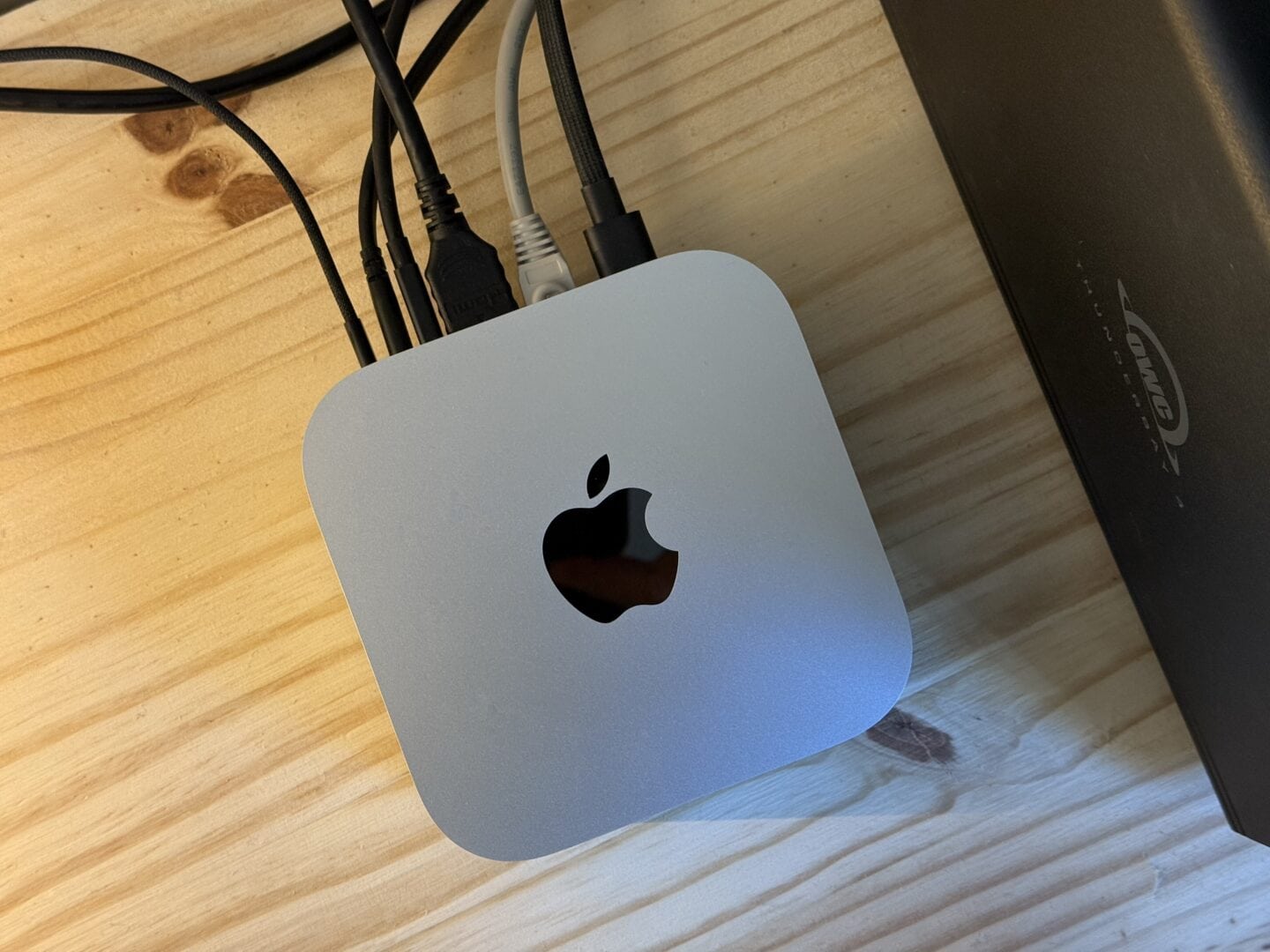 Mac mini M4 pictured from above, with various things plugged into the back.