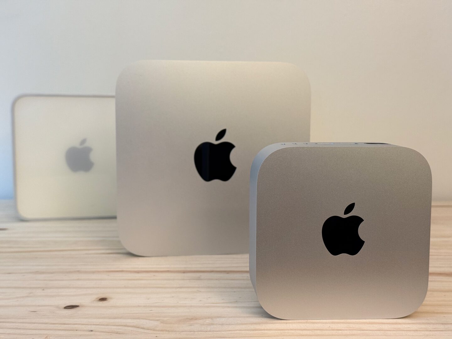 All three Mac mini designs sitting vertically on a table