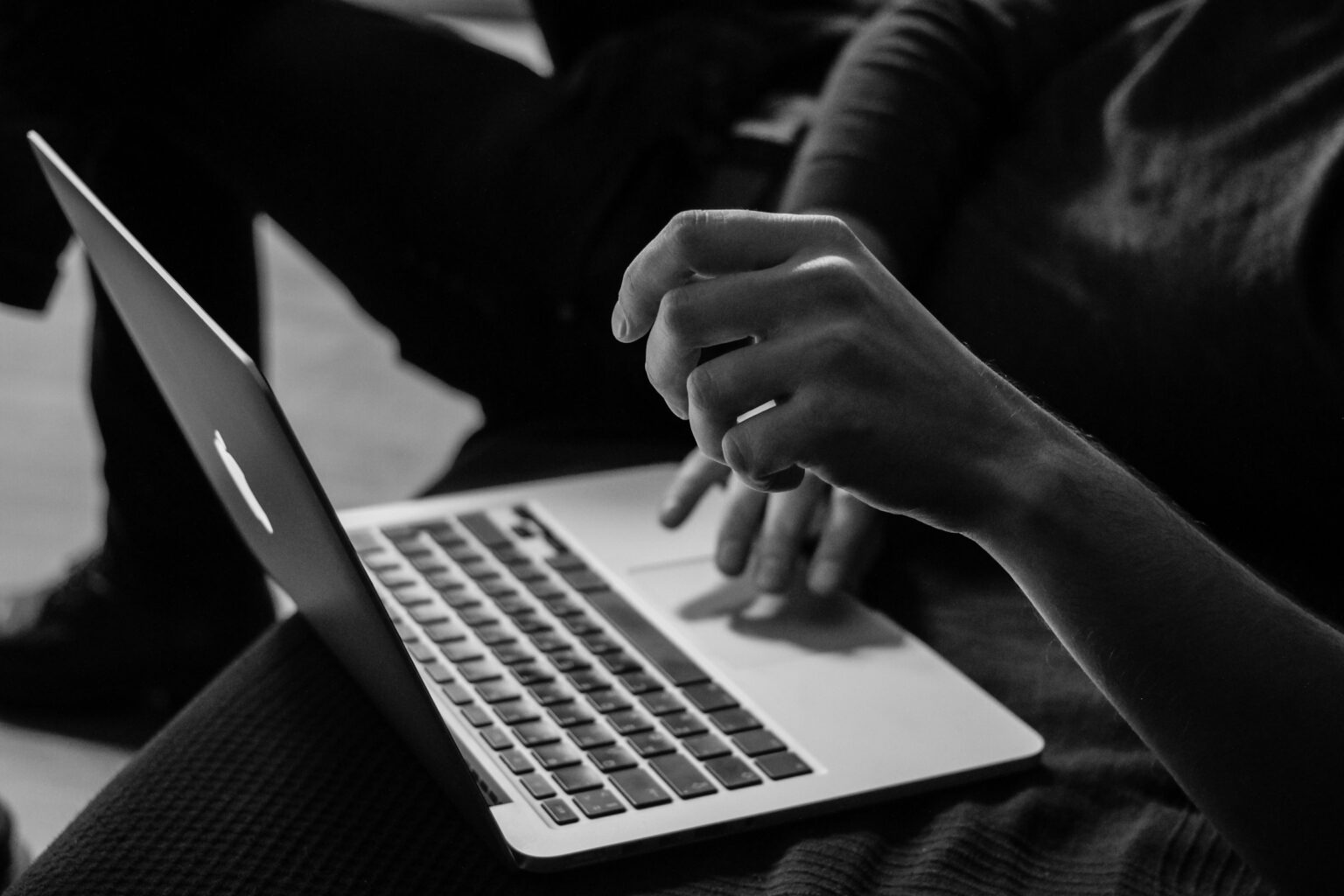 Close-up of a MacBook laptop on a person's lap.